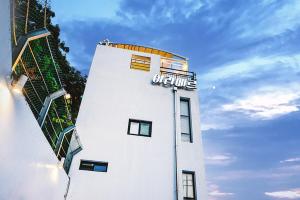 a white building with a sign on top of it at Aramer Spa Pension in Yeosu