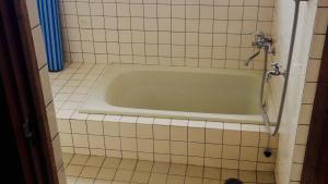 a bath tub in a tiled bathroom with a shower at nano inn in Kanagawa +41 photos