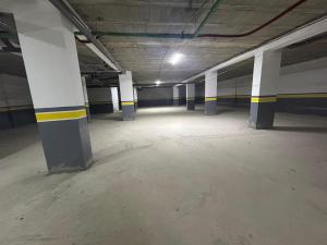 an empty parking garage with white and blue columns at Rmilat Garden N8 vue sur la piscine in Cabo Negro