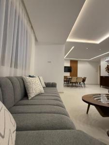 a living room with a couch and a table at Rmilat Garden N8 vue sur la piscine in Cabo Negro
