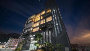 a tall black building with windows at night at Geoje Hinoki Haesoojjim Resort in Geoje 