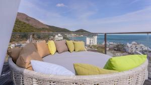 a balcony with a wicker couch and pillows at Geoje Hinoki Haesoojjim Resort in Geoje 