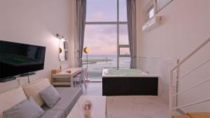 a living room with a couch and a large window at Gangneung Pension G7 Spa Pension in Gangneung