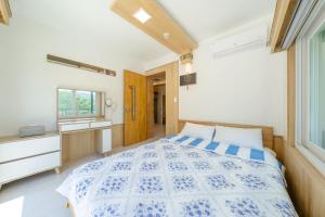 a bedroom with a blue and white bed and a window at Gapyeong Therisome Poolvilla in Gapyeong +5 photos