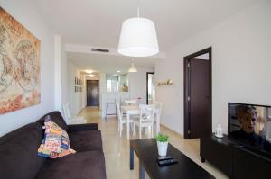 a living room with a couch and a table at Residencial Linnea Sol by Mar Holidays in Playas de Orihuela