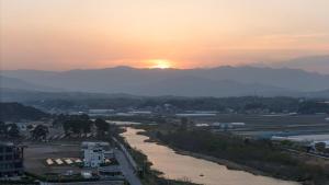 a view of a river with the sunset in the background at Gangneung Travel Good Camping Pension in Gangneung