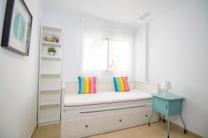 a room with a white bench with pillows and a window at Residencial Linnea Sol by Mar Holidays in Playas de Orihuela +44 photos