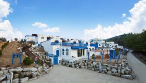 a group of white and blue buildings on a hill at Yangyang Jijoonghae Pool Villa in Yangyang