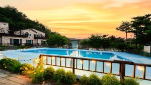 a large swimming pool with a fence around it at Sokcho White House Swimming Pool Pension in Sokcho