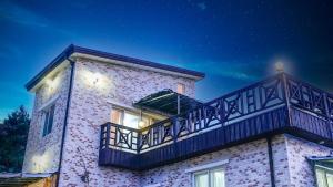 a building with a balcony on top of it at Sokcho White House Swimming Pool Pension in Sokcho