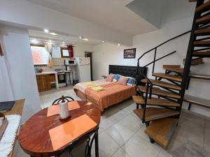 Una sala de estar con una cama y una cocina. en Monoambiente "B" a 7 minutos del centro en auto, en Ushuaia