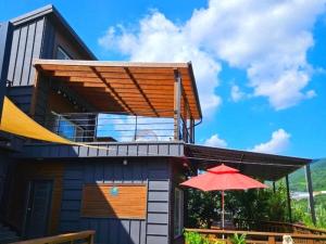a house with a red umbrella in front of it at Sancheong Jarak Ae Pension in Sancheong