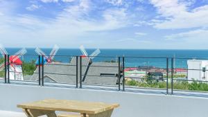 Un balcón con mesa y vista al mar. en Gangneung YOLO Ocean View Spa Pension, en Gangneung