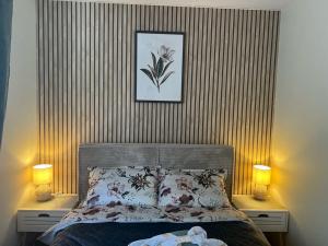a bedroom with a bed with two lamps and a picture at Tenno Apartment 3 in Kudjape