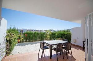 a table and chairs on a patio with a view at Residencial Linnea Sol by Mar Holidays in Playas de Orihuela