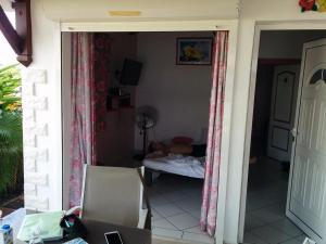 een persoon die op een bed in een kamer ligt bij Gîte Hibiscus piscine partagée in Saint-François