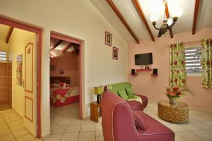een woonkamer met een bank en een bed bij Gîte Hibiscus piscine partagée in Saint-François