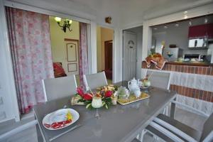 een eetkamer met een tafel met eten erop bij Gîte Hibiscus piscine partagée in Saint-François