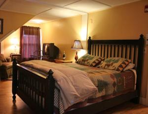 ein Schlafzimmer mit einem großen Bett und einem TV in der Unterkunft Wildcat Inn and Tavern in Jackson