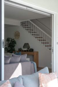 a living room with a couch and a staircase at Solar Pool & Luxury Beach Villa in Bokarina