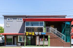 a building with a sign in front of it at Reedforest Pension Suncheon in Suncheon