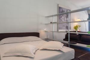 a bedroom with two beds and a couch and shelves at Faro Apartments in Chania
