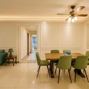 a dining room with a table and green chairs at R&F Princess Cove JB Apartment Suites By SC Homestay in Johor Bahru