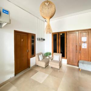 a living room with two chairs and a chandelier at Village Homestay Yogyakarta RedPartner in Yogyakarta +11 photos