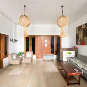 a living room with two chandeliers and a couch at Village Homestay Yogyakarta RedPartner in Yogyakarta