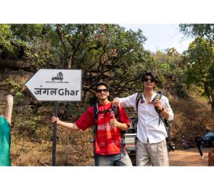 two men are standing in front of a sign at Jungle Ghar in Pachmarhī