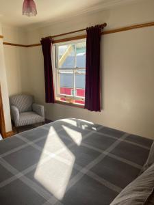 a bedroom with a bed and a window at Alice Cottage - South St Townhouse Treasure in the Heart of Nelson in Nelson
