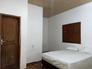 a bedroom with a bed and a wooden door at JLM Pereira in Marituba