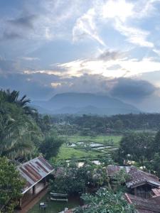 a view of a village with mountains in the distance at Krakatau Guest House in Saroako