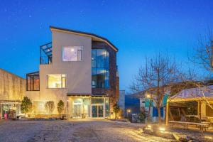 a large house with glass windows at night at Nami Island Koi Pension in Gapyeong