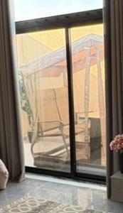 Blick auf einen Stuhl durch eine Glasschiebetür in der Unterkunft A new studio near the airport in Quai