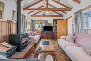 un salon avec un canapé et une cheminée dans l'établissement Okere Retreat - Lake Rotoiti Getaway, à Okere Falls