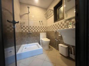 a bathroom with a shower and a toilet and a sink at Leanitai luxury 1-BR Apartment-203 at Qatif شقة فاخرة بغرفة نوم واحدة in Tārūt +8 photos