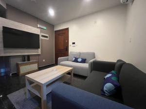 a living room with a couch and a tv at Leanitai luxury 1-BR Apartment-203 at Qatif شقة فاخرة بغرفة نوم واحدة in Tārūt