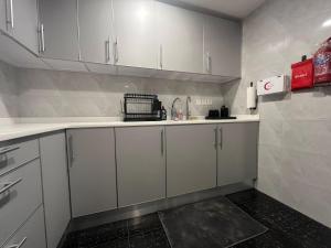 a kitchen with white cabinets and a sink at Leanitai luxury 1-BR Apartment-203 at Qatif شقة فاخرة بغرفة نوم واحدة in Tārūt