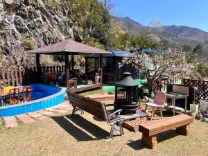 un patio trasero con parrilla, mesa y sillas en Gangneung Happy Pension, en Gangneung