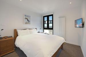 een witte slaapkamer met een groot bed en een raam bij Kabuki 2 - The Residence in Mount Buller
