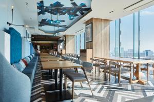 a restaurant with tables and chairs and windows at Mitsui Garden Hotel Nagoya Premier in Nagoya