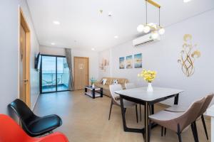 a dining room and living room with a table and chairs at Aria Vũng Tàu Resort - Căn hộ & Villa in Vung Tau