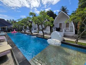 an outdoor swimming pool with an inflatable blob in front of a house at Gili Sal EE in Gili Trawangan