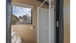 a bathroom with a window and a white toilet at Avon River Homestead by Tiny Away in Beverley +40 photos