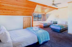 una camera da letto con due letti e un ventilatore a soffitto di The Lake House a Lake Tekapo