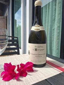 una botella de vino sentada en una mesa con flores rojas en Peaceful Pool Villa 1, en Ao Nang Beach