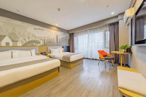 武漢市にあるThank Inn Hotel Hubei Wuhan Caidian Zhong Fa Xincheng Tongjiのベッド2台とテレビがあるホテルの部屋 +26枚の写真