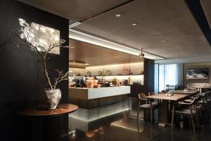 a restaurant with tables and chairs and a kitchen at Atour S Hotel Tianshan Road in Shanghai