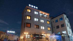 a tall building with its lights on at night at Gapyeong TwoTwo Spa Pension in Gapyeong